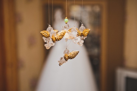 Figures of angels hang against a dress.の写真素材