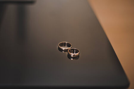 Wedding rings lie on a smooth table.の写真素材