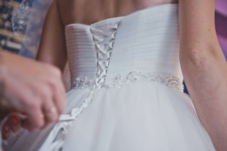 The girl dresses a wedding dress.