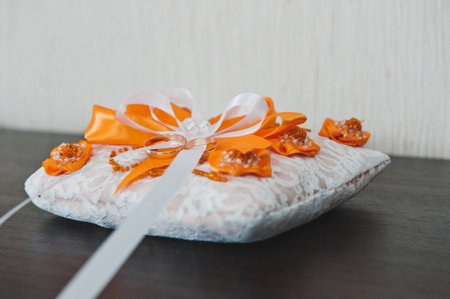 Wedding rings lie on a decorative pillow.の写真素材