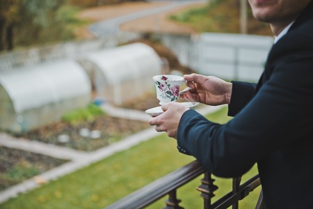 Cup of tea in hands of the young man.の写真素材