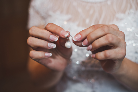 Beautiful earring in female hands.の写真素材