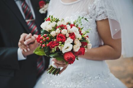 Bouquet in hands of the newly-married couple.の写真素材