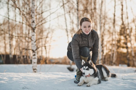 The girl walks with a dog in the winter.の写真素材