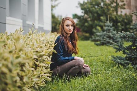 The girl sits about a bush.の写真素材