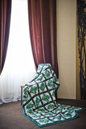 The blanket sewed manually from pieces of a fabric.