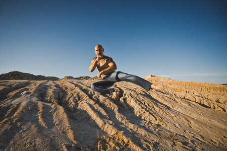The man jumps on sandy barkhans at sunset.の写真素材