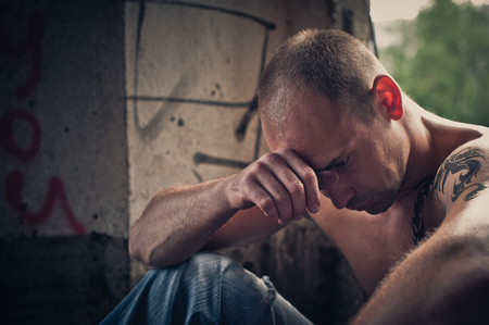 The man sits in thoughts among ruins of structures.の写真素材