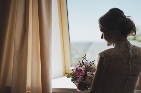 Girl waiting for the groom at the window.の写真素材