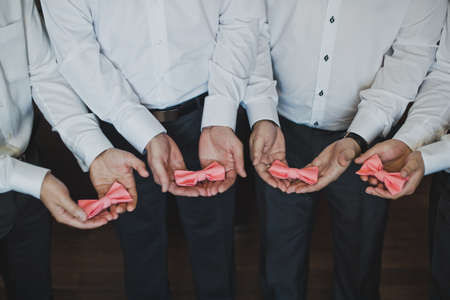 The groomsmen are holding the ties.の写真素材