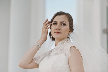 Portrait of a girl in a white dress and veil around the columns.の写真素材