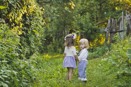 The children walk along the summer garden.の写真素材