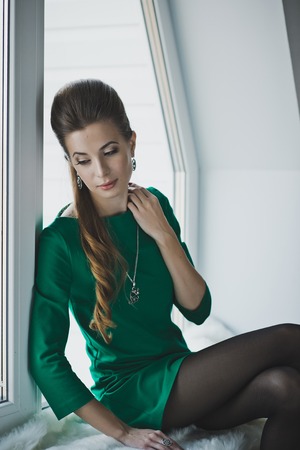 The girl in the green dress on the windowsill.の写真素材