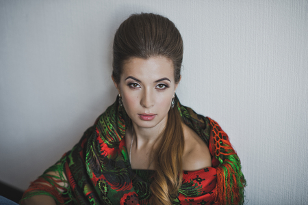 Girl sitting near the wall wrapped in the colored handkerchief.の写真素材
