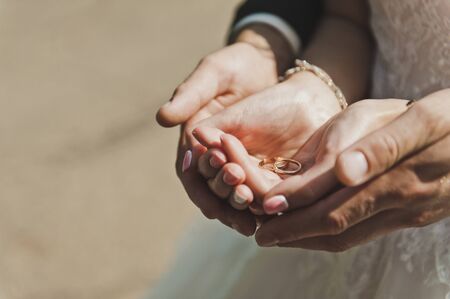 Mans and female hands hold wedding rings.の写真素材