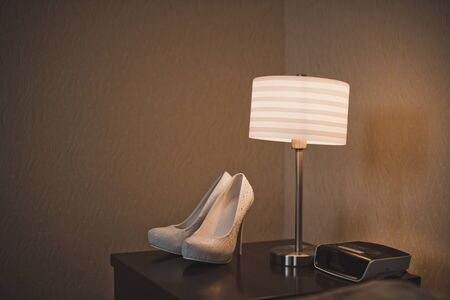 On the table there are white shoes and a Desk lamp.の写真素材