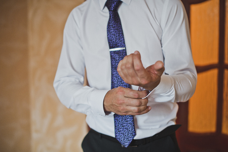 The process of dressing the shirt of the man.の写真素材