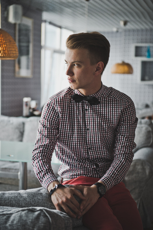 Portrait of a boy in a striped shirt and a bow tie in the cafe.の写真素材
