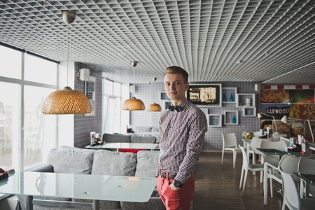 Portrait of a boy in a striped shirt and a bow tie in the cafe.の写真素材