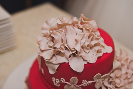Red cake with beige flowers.