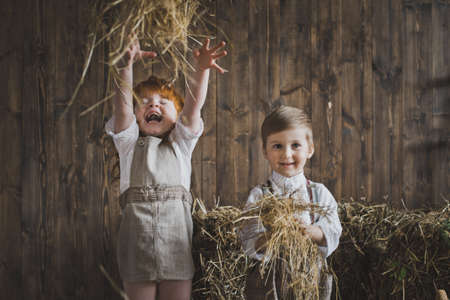 Portrait of children throwing hay.の写真素材