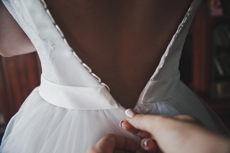 The process of dressing the wedding dress to the bride.の写真素材