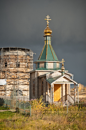 A wooden chapel on the background of the restored Church.の写真素材