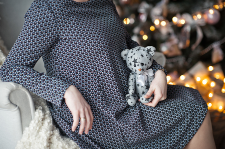 The girl holds on her knees a plush toy.の写真素材