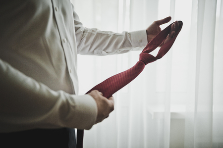 The young man wears a red tie.の写真素材