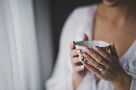 The bride sits with glass in hand.の写真素材