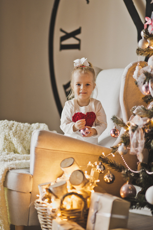 Portrait of baby in front of a big Christmas tree and the chimes of the dial.の写真素材