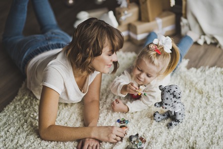 Child and parent play with toys on the floor.の写真素材