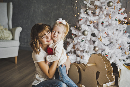 The embrace of a mother and daughter near the Christmas tree.の写真素材