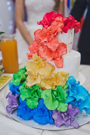 Cake decorated with flowers of all colors of the rainbow.の写真素材