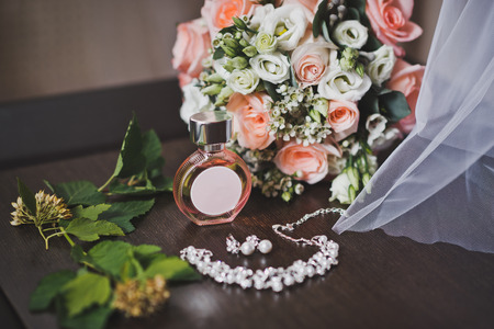 Perfume necklace and bouquet flowers on the little table.の写真素材