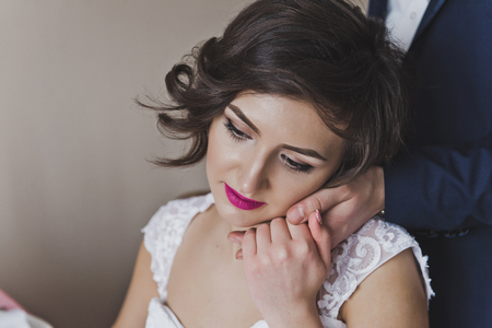 The bride gently pressed her cheek to the hand of her husband.の写真素材