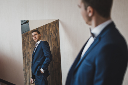 Male assesses her outfit in the mirror.の写真素材