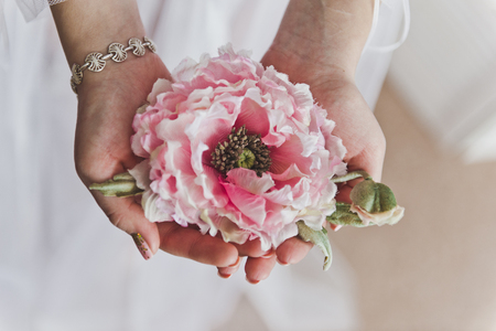 Big pink flower in female hands.の写真素材