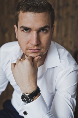 Portrait of a young man sitting on a chair.の写真素材