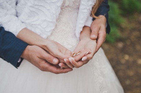 The gentle embrace of hands of the newlyweds.