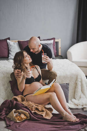 The husband brought Breakfast to bed to his pregnant wife.の写真素材
