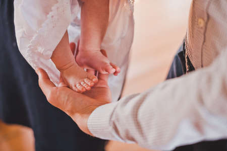 The priest rubs the baby's feet.の写真素材