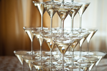 Champagne-filled wine glasses in the pyramid.の写真素材