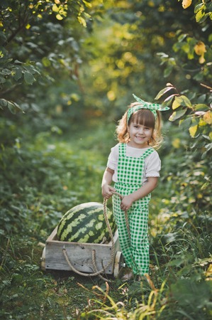 Portrait of a child with a huge watermelon in the cart.の写真素材
