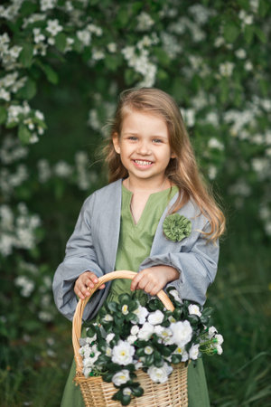 Happy young girl carrying a basket of flowers.の写真素材