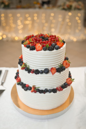 Beautiful three-tiered cake decorated with colorful flowers.の写真素材