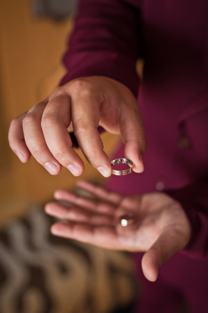 Two wedding rings in the hands of a young guy.