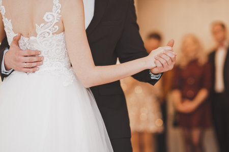 The groom holds the brides hand while dancing at the wedding.の写真素材