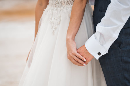The newlyweds tenderly hold hands.