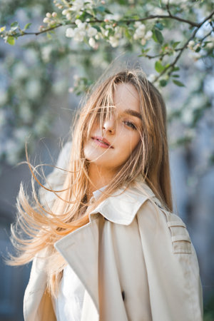 Portrait of a red-haired beauty on the background of a cherry blossom.の写真素材
